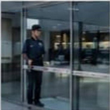 Security guard managing access at a glass entrance